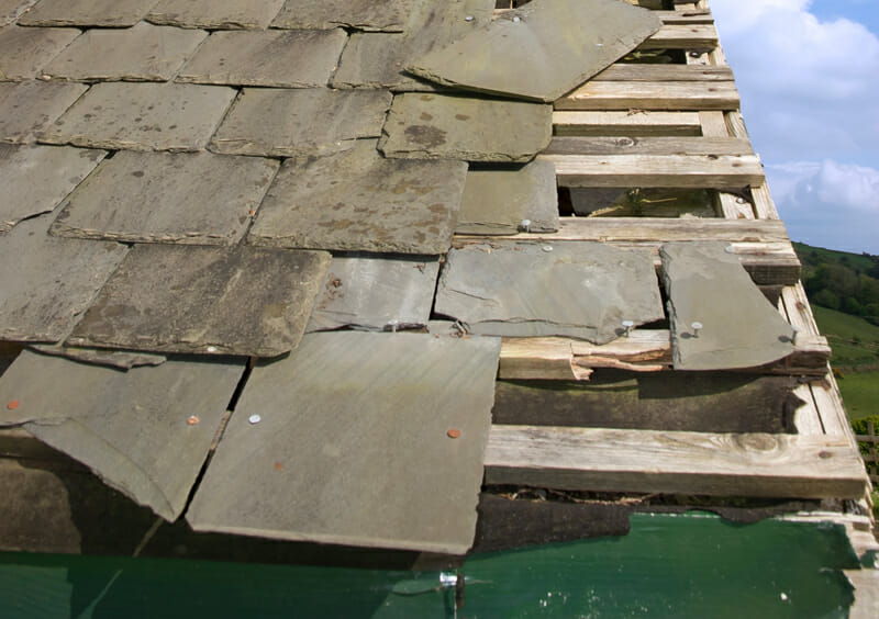 Damaged residential roof caused by a storm in  Robertsville, NJ